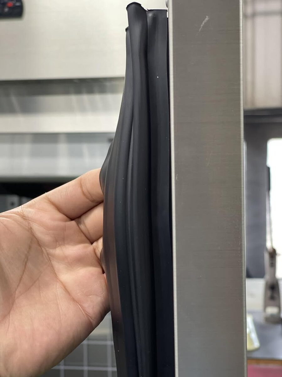 A finger pulling the magnetic door gasket on a TOROL chiller